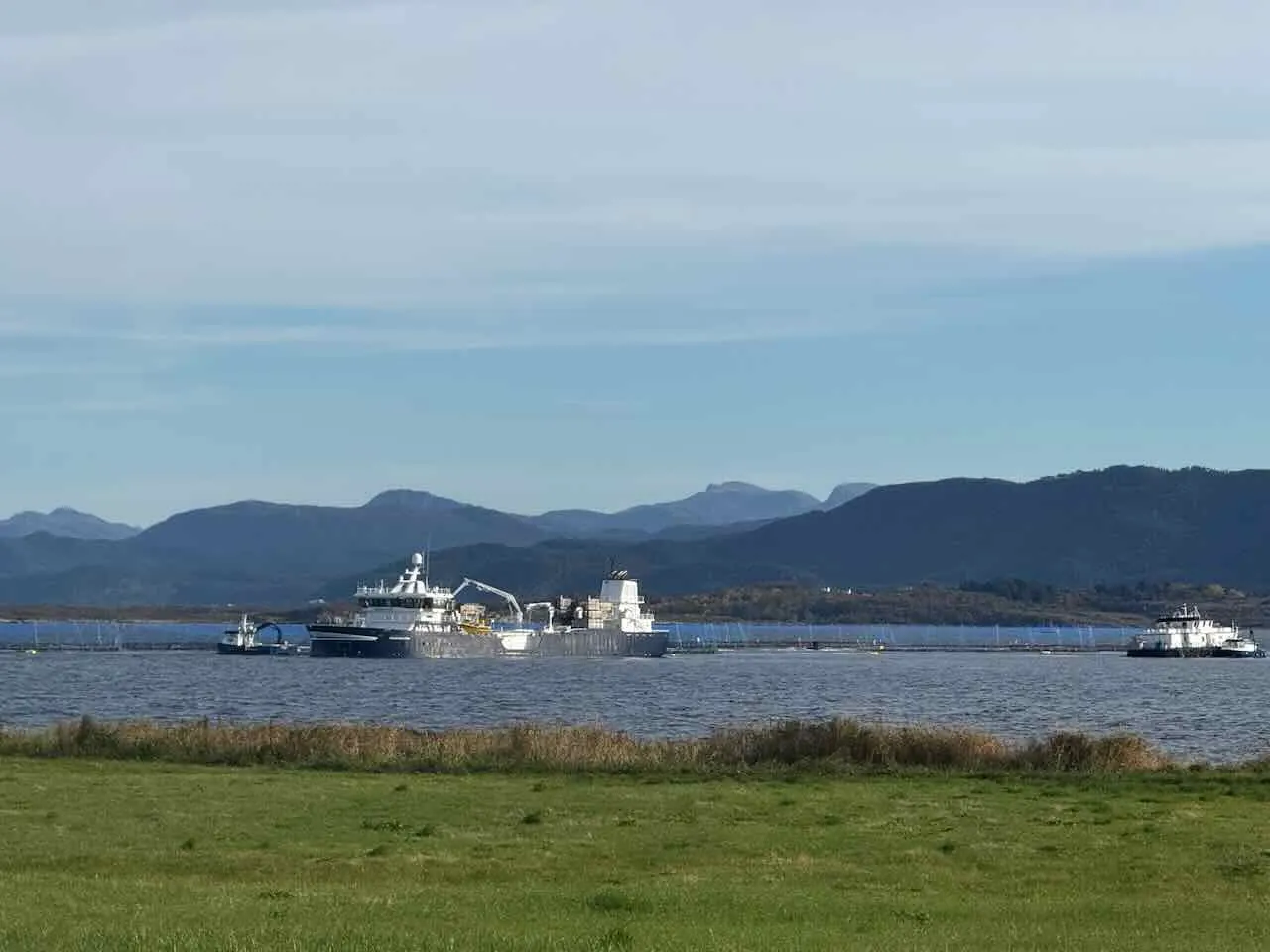 Aquaculture vessels working at a fish farm in a Norwegian fjord